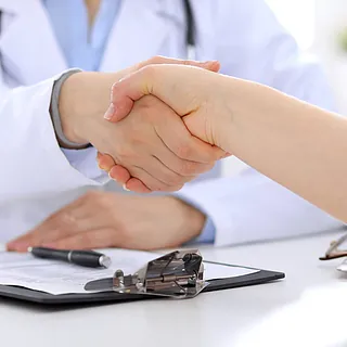 Ärztin schüttelt Hände mit Patienten